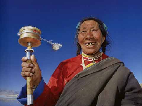 
Pilgrim Woman Spinning Prayer Wheel At Lake Manasarovar - Buddhism: Eight Steps To Happiness by Dieter Glogowski book
